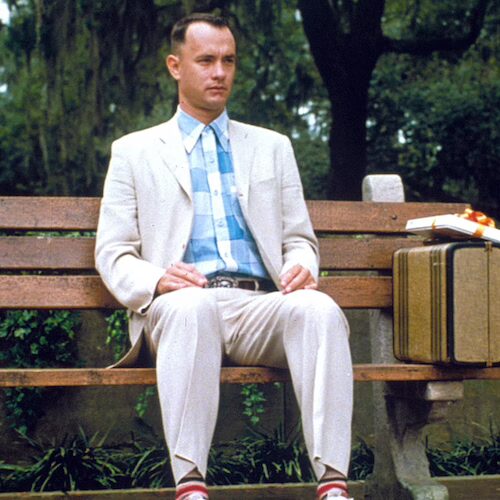 Постер фильма Форрест Гамп (Forrest Gump) с изображением главного героя, сидящего на скамейке с чемоданом, и названием фильма.